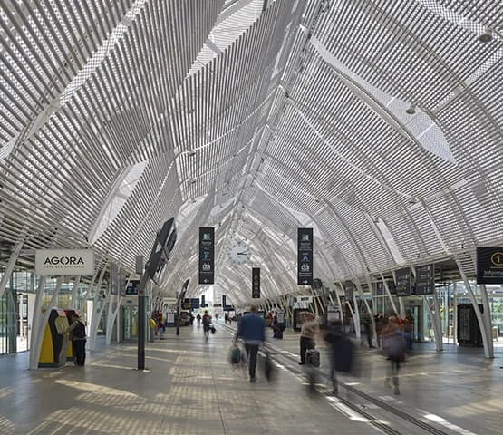 Charpente métallique et verrière à l’intérieur d’une gare.