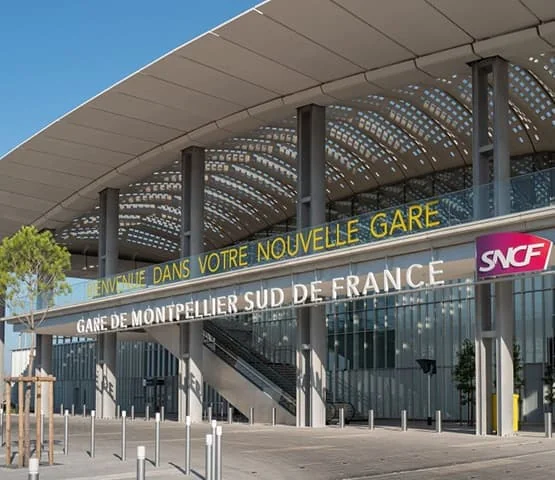 Façade de la gare Montpellier Sud de France sous un large auvent.