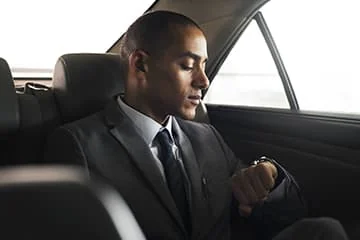 Transport Business Herault Homme en costume assis à l’arrière d’une voiture.