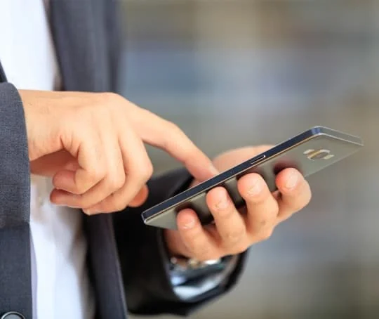 Mains utilisant un téléphone portable.